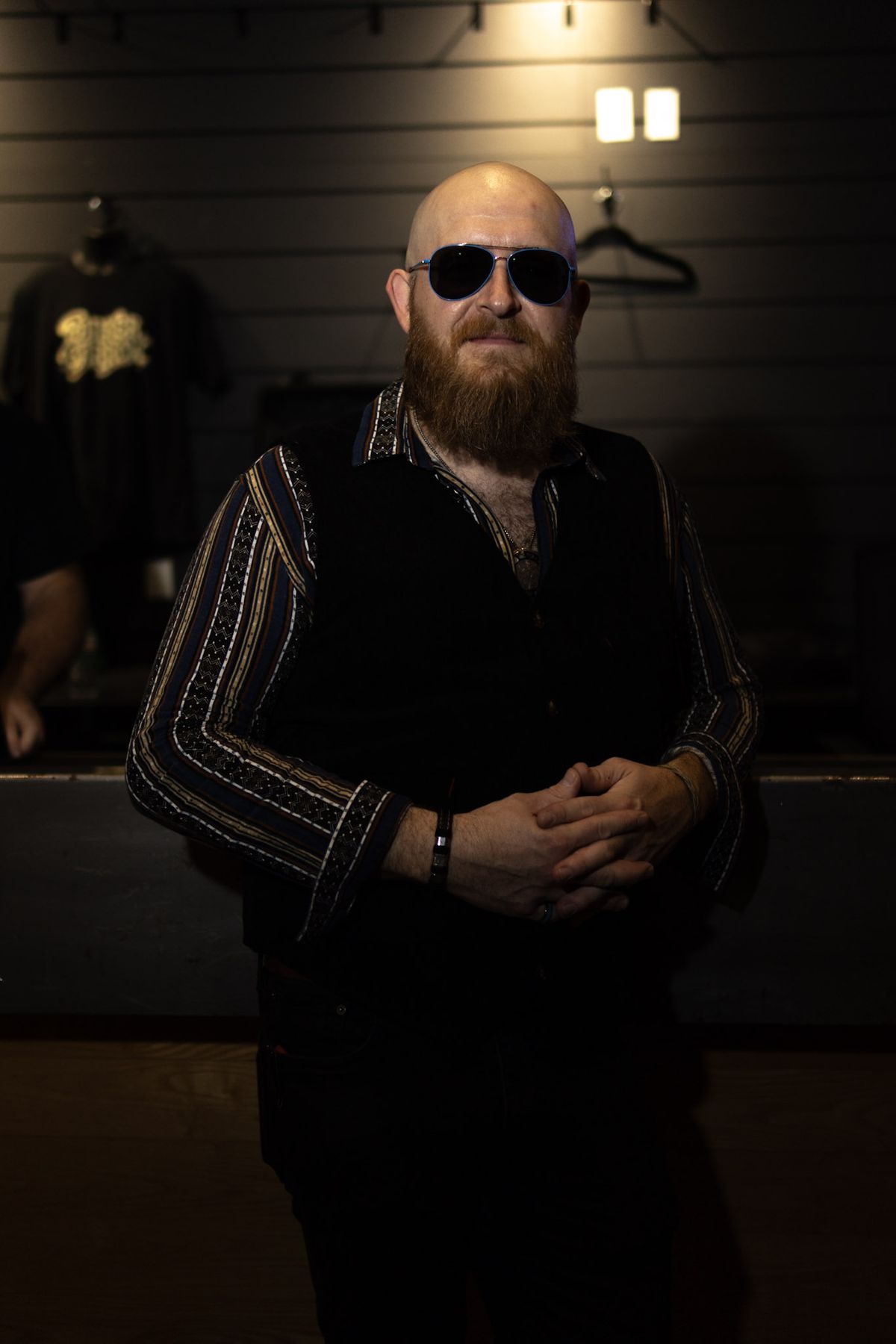 Bearded man in sunglasses standing in a dark venue