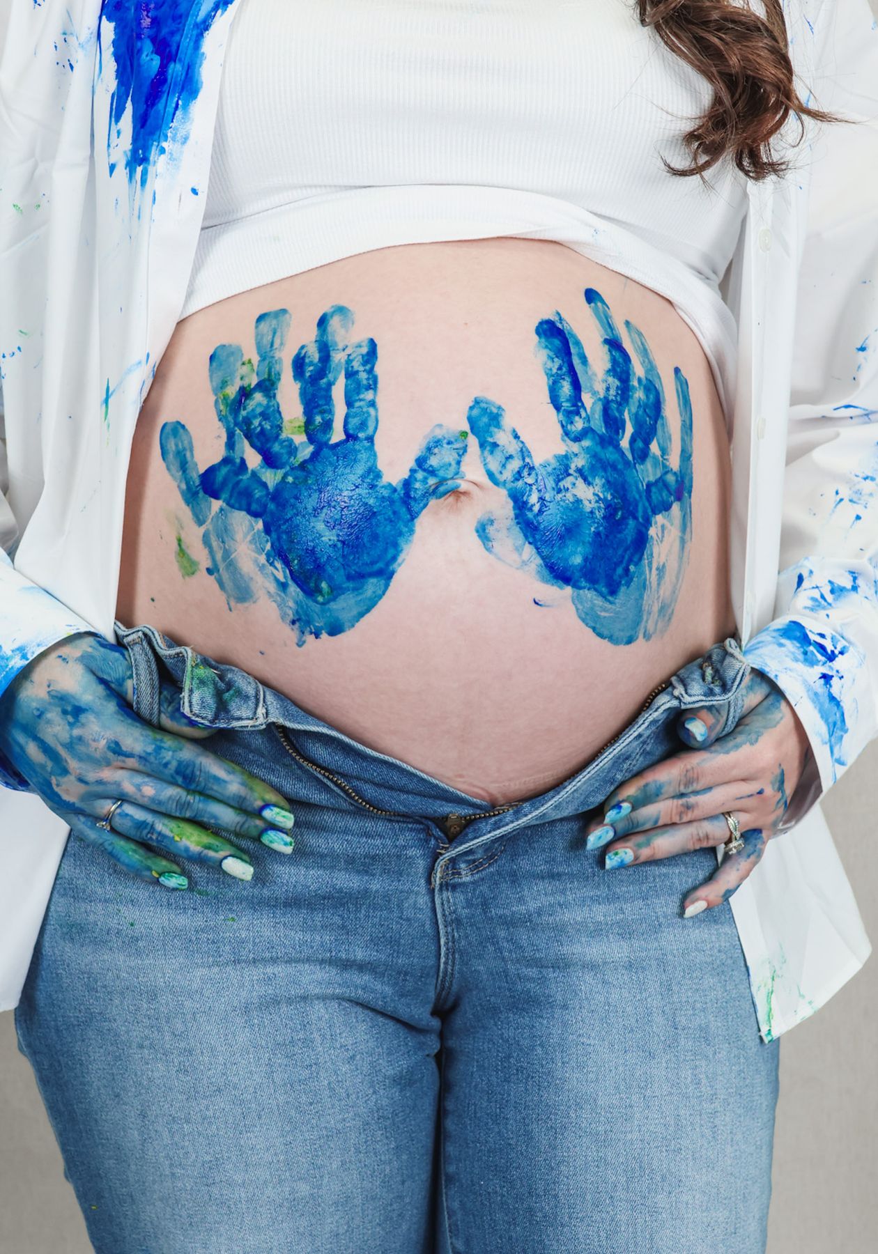 Blue painted handprints on an expecting mother's belly